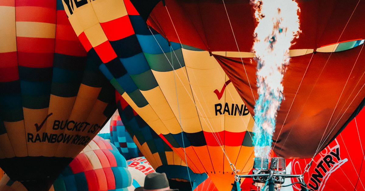 Colorful hot air balloons inflating with flames, capturing festival excitement in Albuquerque.