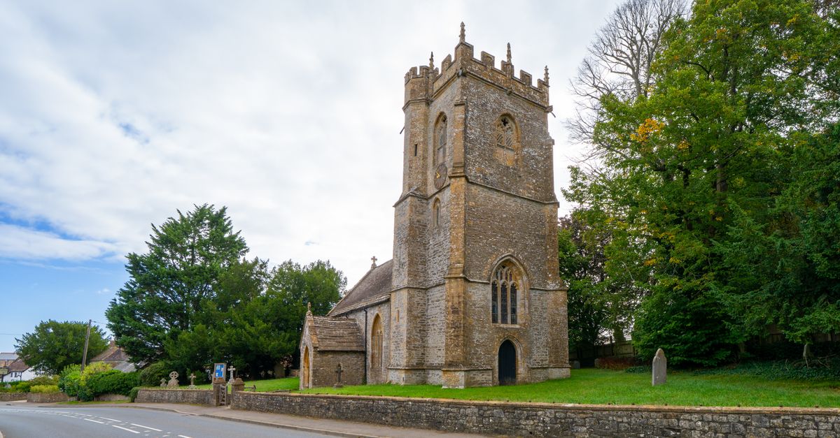A picturesque stone church tower in a peaceful Dorset village setting.