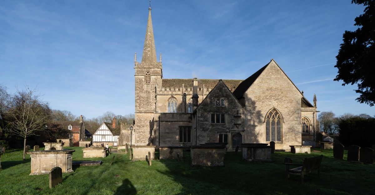 Beautiful stone church in Lacock, England with clear blue sky, perfect for travel and architecture enthusiasts.