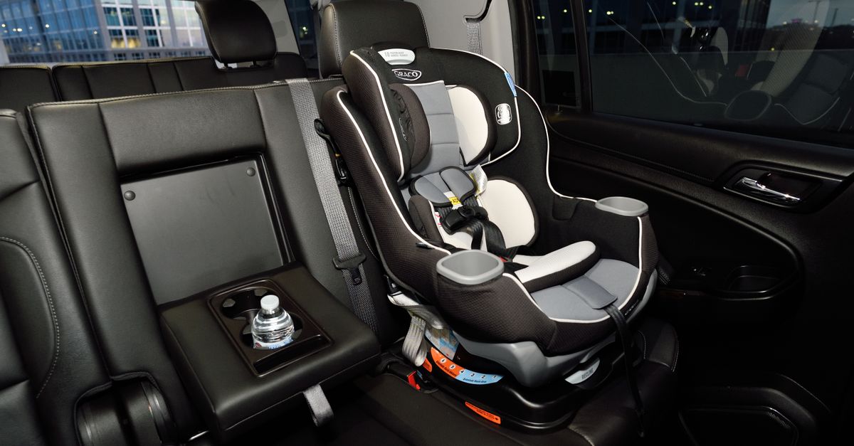An empty child car seat correctly fitted in the back of a car, ready for an airport transfer