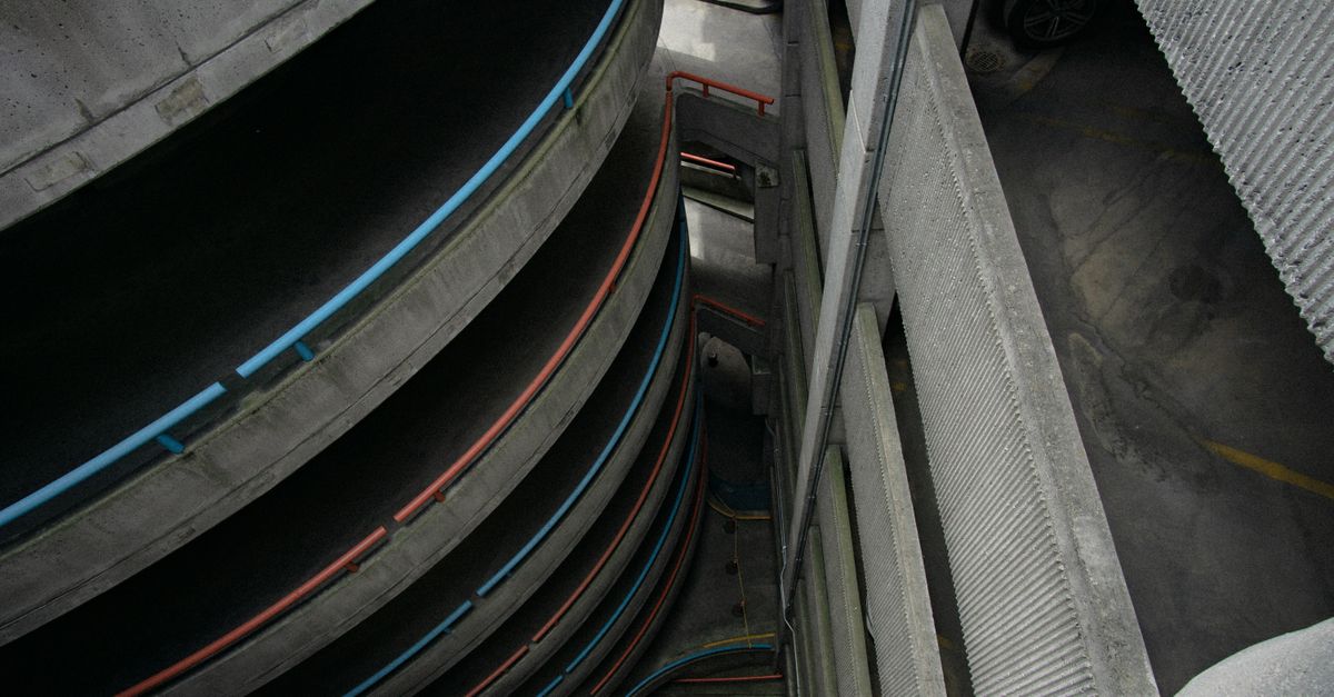 High-angle view of a spiral concrete parking structure, showcasing architectural design.