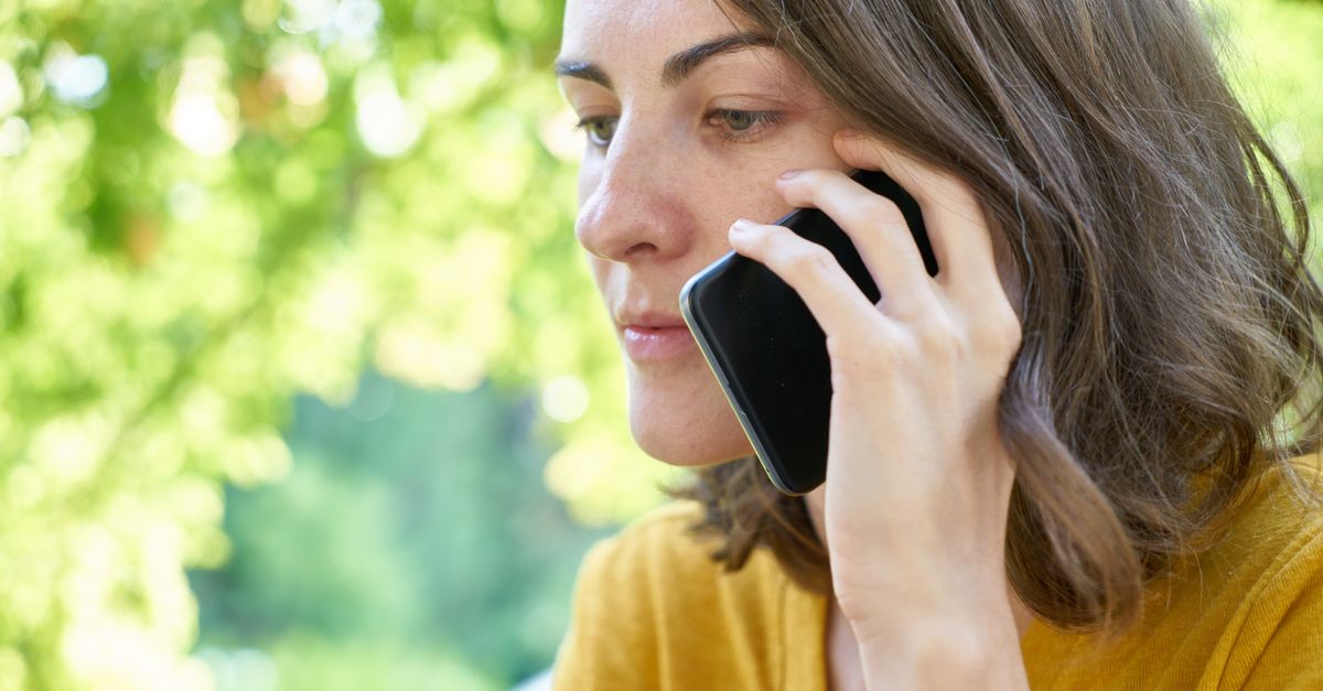 Woman calmly making a phone call outdoors to sort out a booking