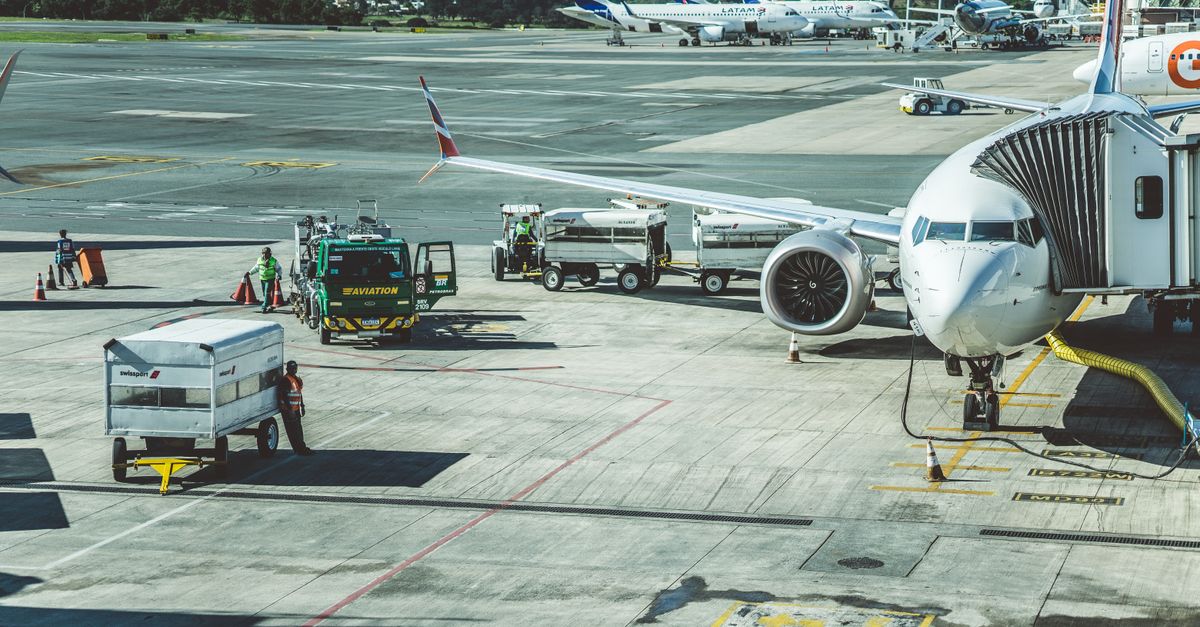 Ground crew preparing a commercial airplane for departure at an airport tarmac.